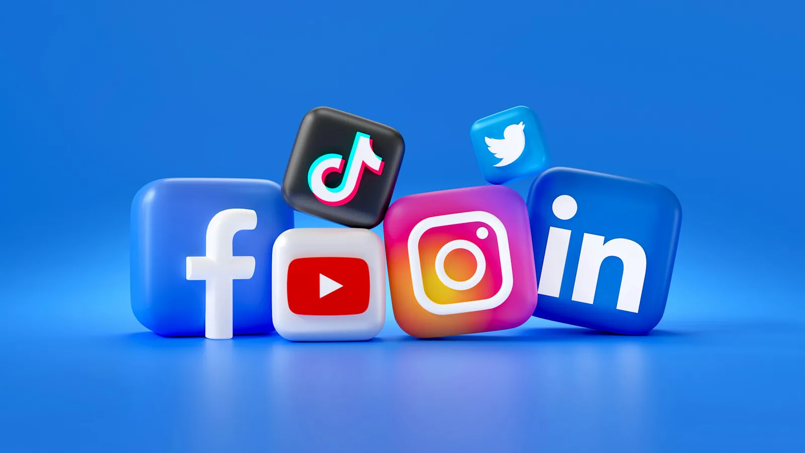 Plastisch gestaltete Symbole von Facebook, TikTok, YouTube, Instagram, LinkedIn und Twitter auf blauem Hintergrund.